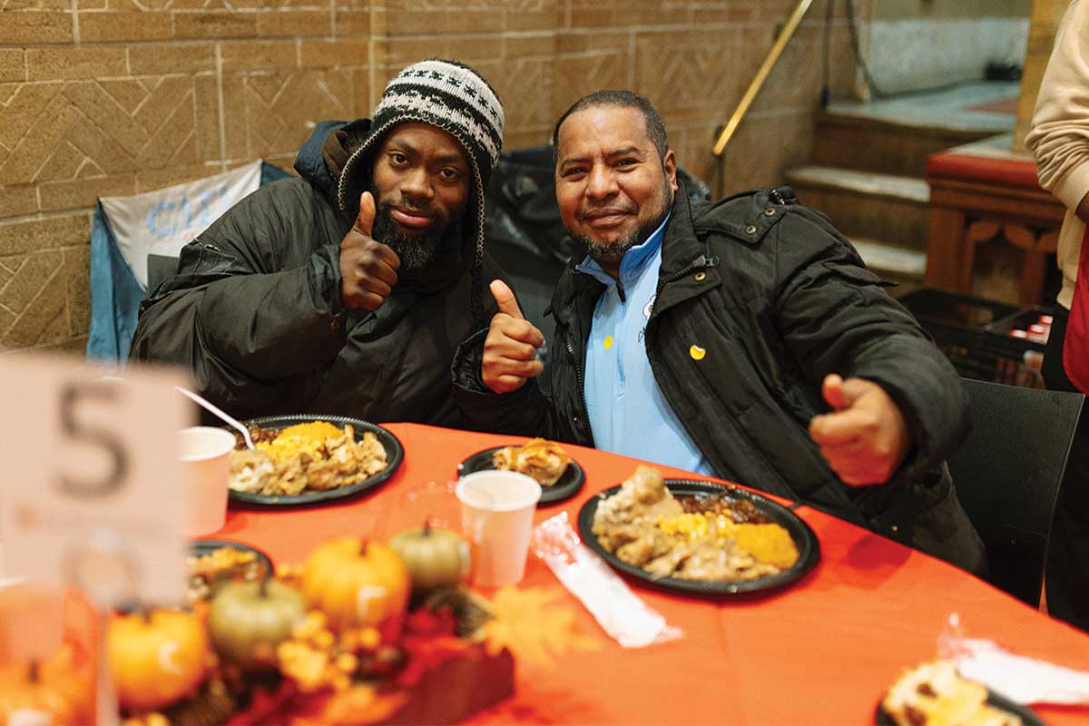 Guests smiling with Thanksgiving meal