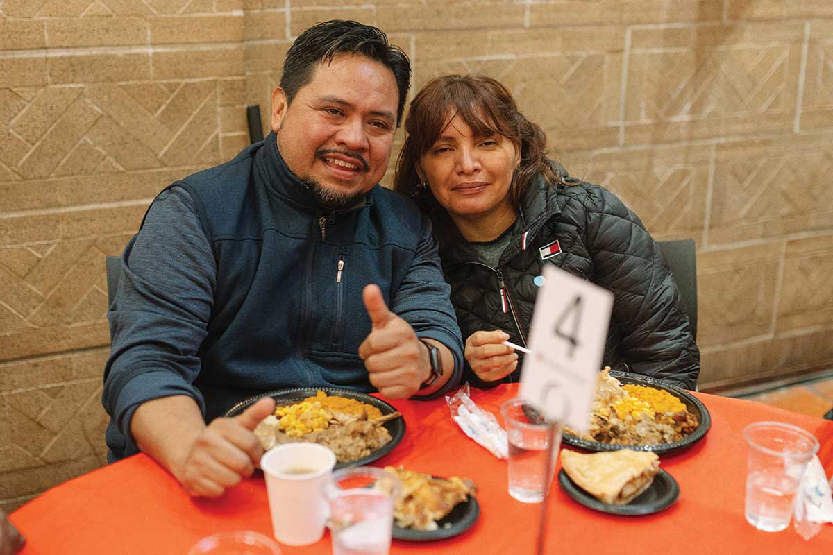 Guests smiling with Thanksgiving meals